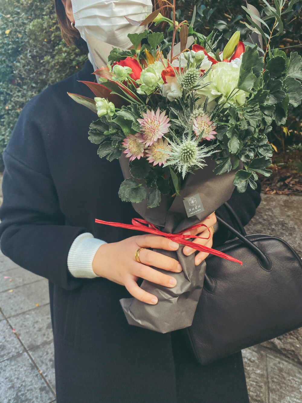 ブラック系のショルダーバッグ、ブラック系のジャケット/アウター、ベージュ系のニット/セーターを着用したレディースの冬コーディネートの2枚目の写真