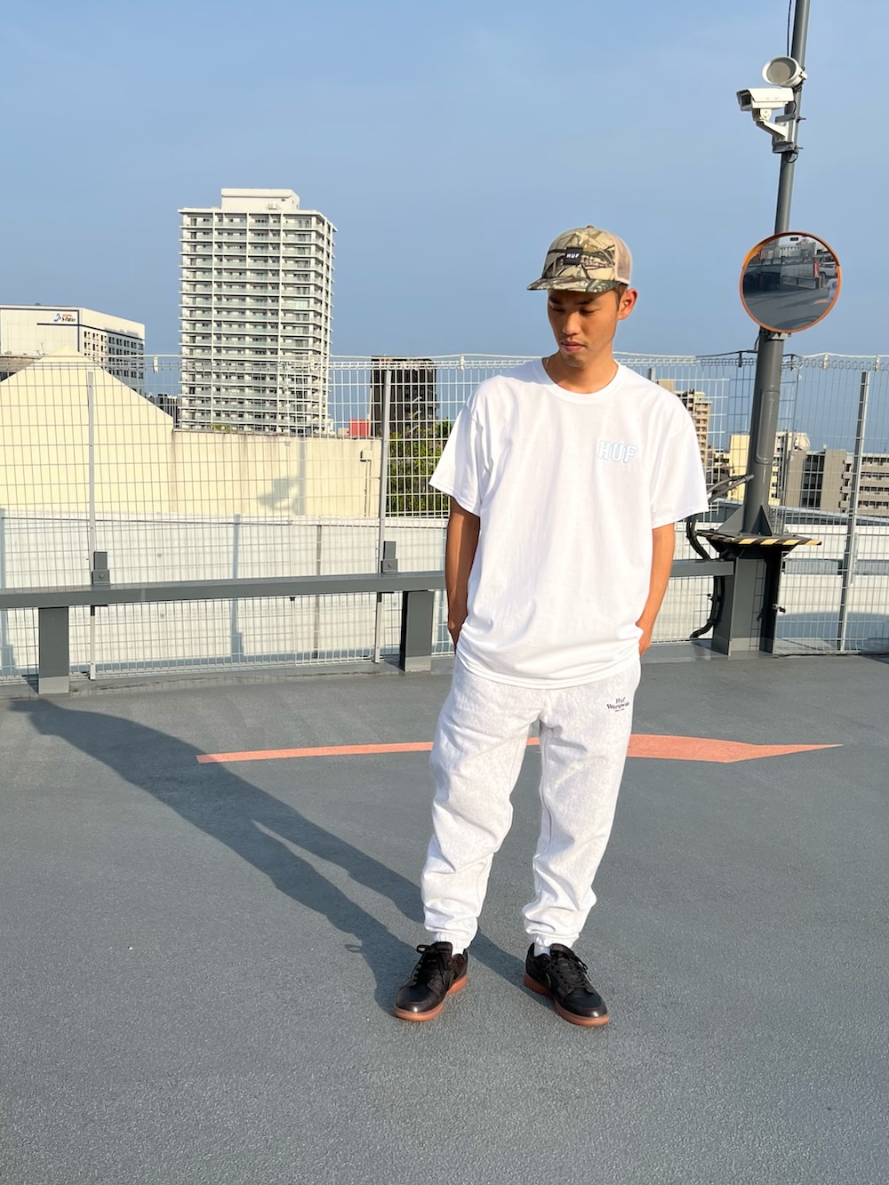 ホワイト系のTシャツ/カットソー、グレー系のパンツ、その他のキャップを着用したメンズの春コーディネートの2枚目の写真