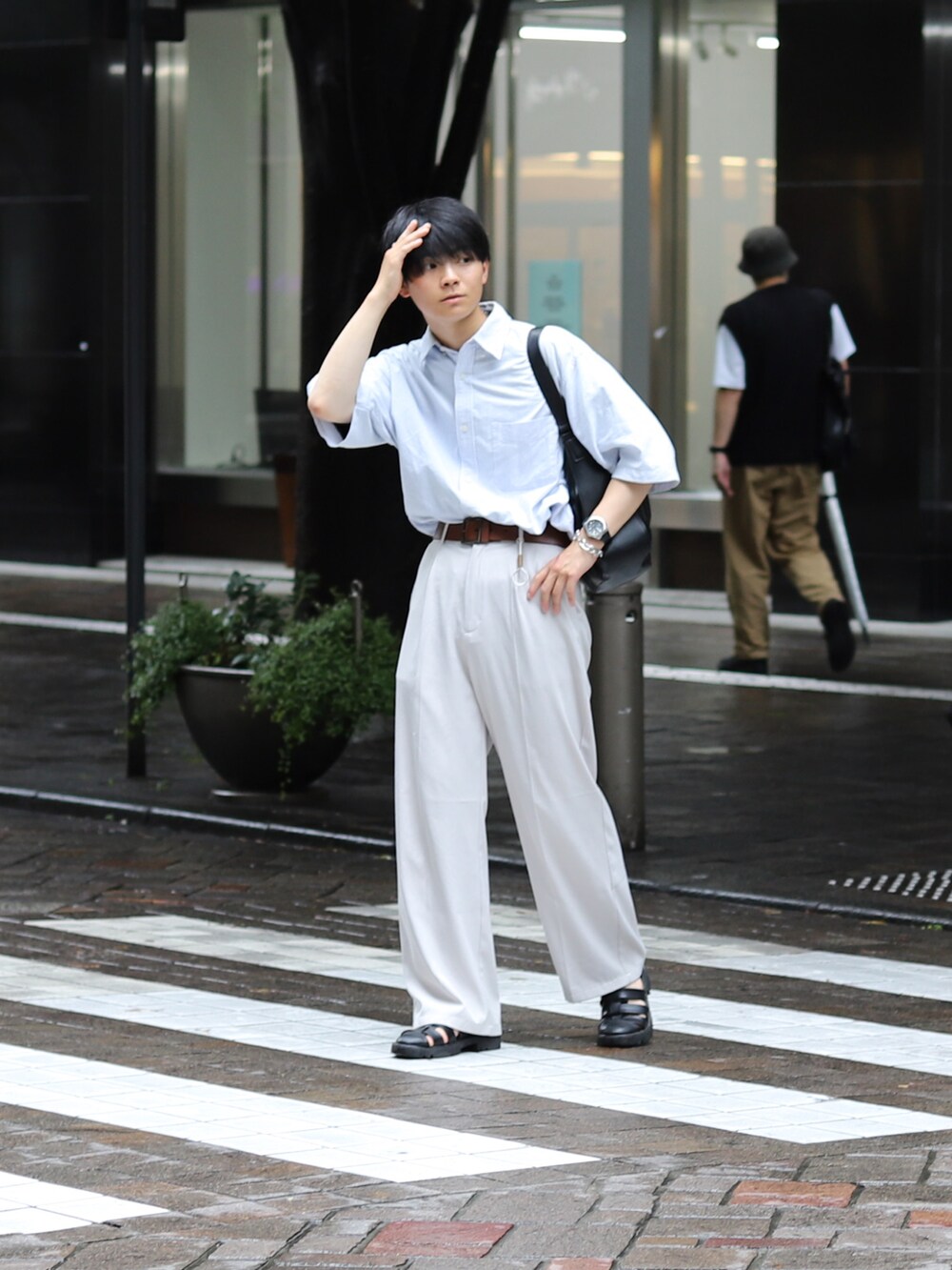 ホワイト系のスラックス、ブラック系のサンダル、ブラック系のバッグを着用したメンズの夏コーディネートの4枚目の写真