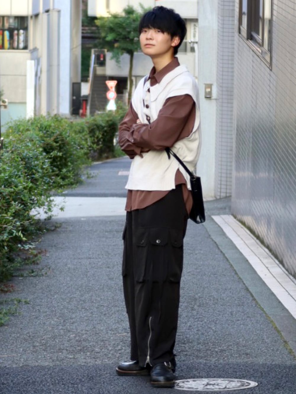 ブラック系のデニムパンツ、ホワイト系のベスト、ブラウン系のシャツ/ブラウスを着用したメンズの秋コーディネートの3枚目の写真