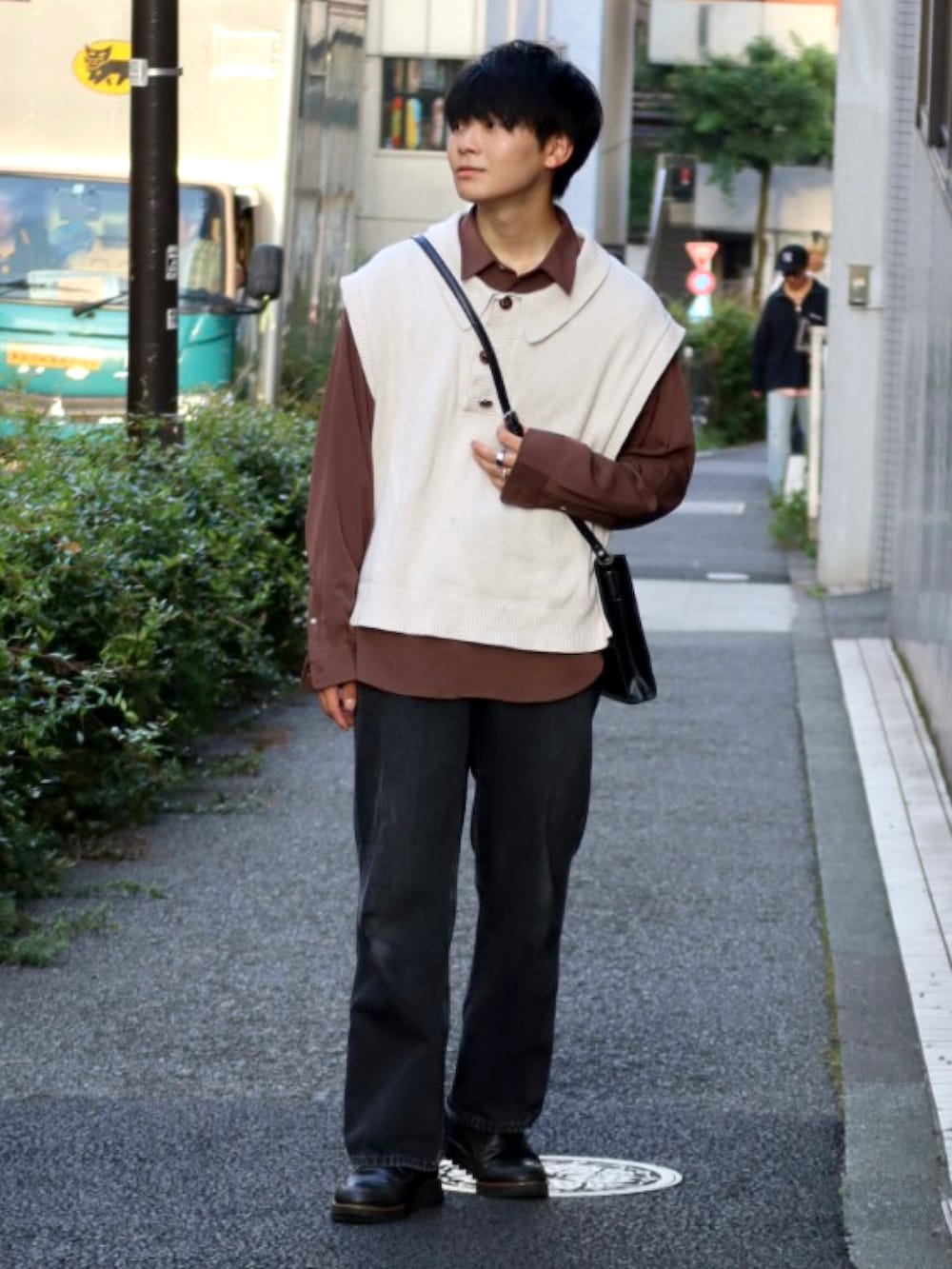 ブラック系のデニムパンツ、ホワイト系のベスト、ブラウン系のシャツ/ブラウスを着用したメンズの秋コーディネートの2枚目の写真