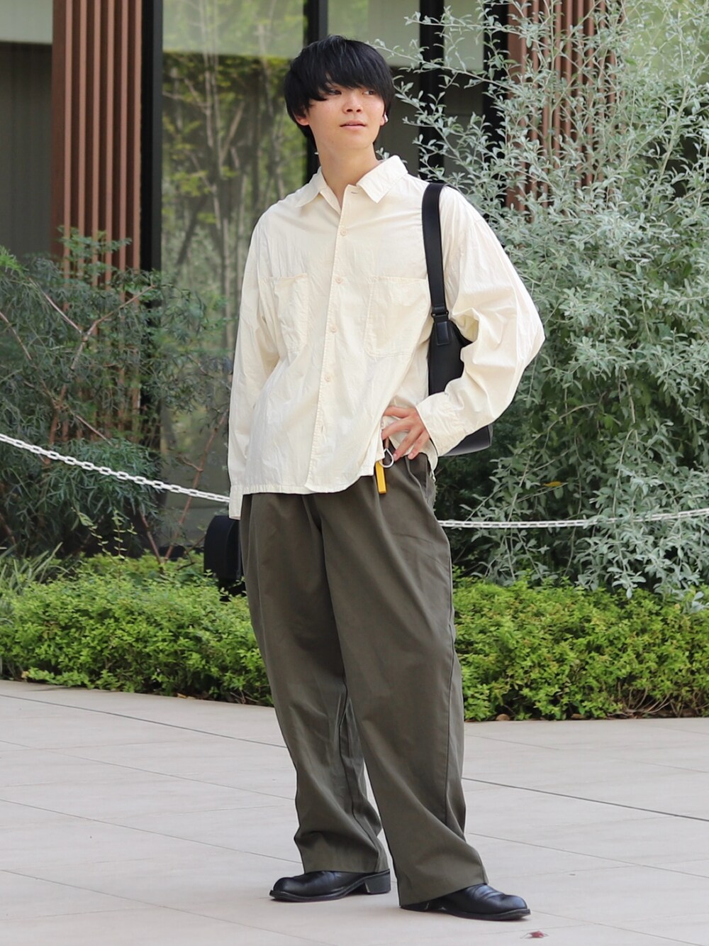 イエロー系のシャツ/ブラウス、ブラック系のバッグ、グリーン系のチノパンツを着用したメンズの夏コーディネートの2枚目の写真