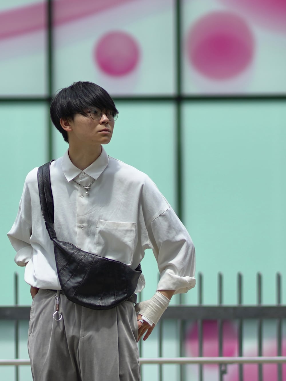 ブラック系のサンダル、グレー系のスラックス、ブラック系のバッグを着用したメンズの夏コーディネートの4枚目の写真