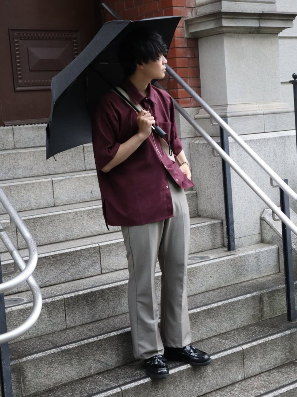 グレー系のスラックス、レッド系のシャツ/ブラウスを着用したメンズの夏コーディネートの3枚目の写真