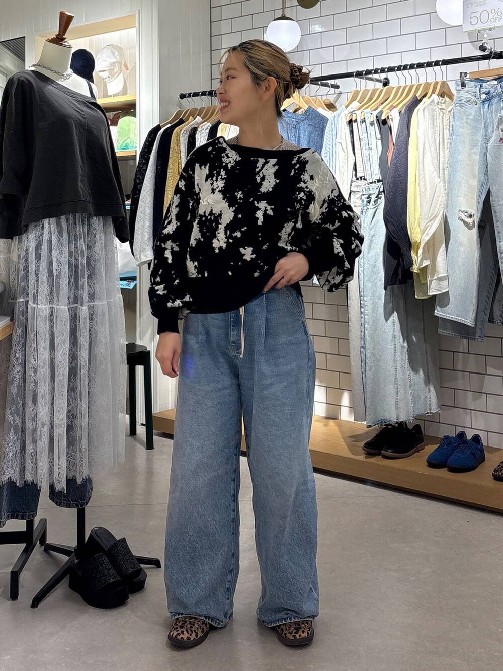 ブルー系のデニムパンツ、その他のスニーカー、ブラック系のカーディガン/ボレロを着用したレディースの春コーディネートの2枚目の写真