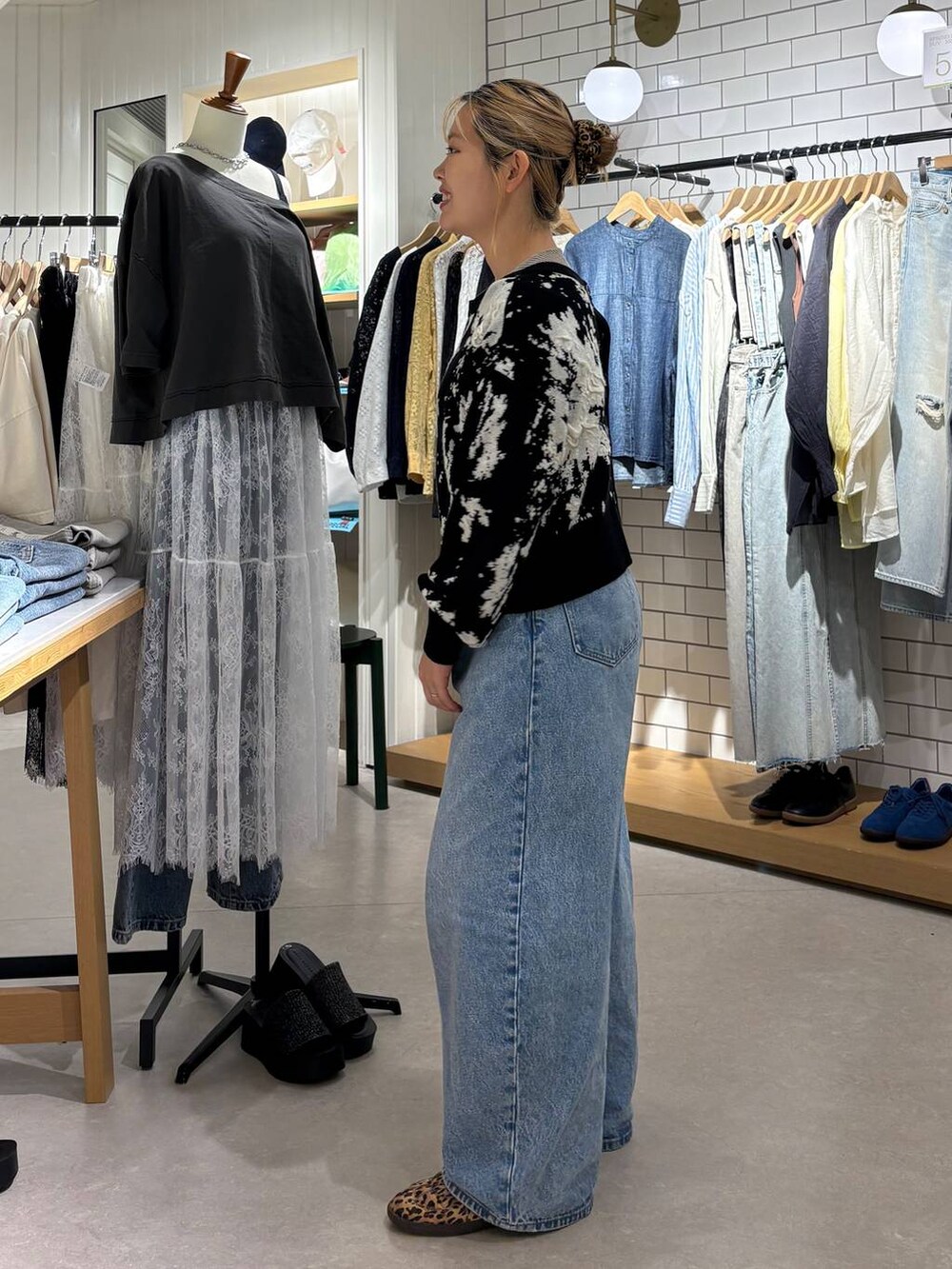 ブルー系のデニムパンツ、その他のスニーカー、ブラック系のカーディガン/ボレロを着用したレディースの春コーディネートの3枚目の写真