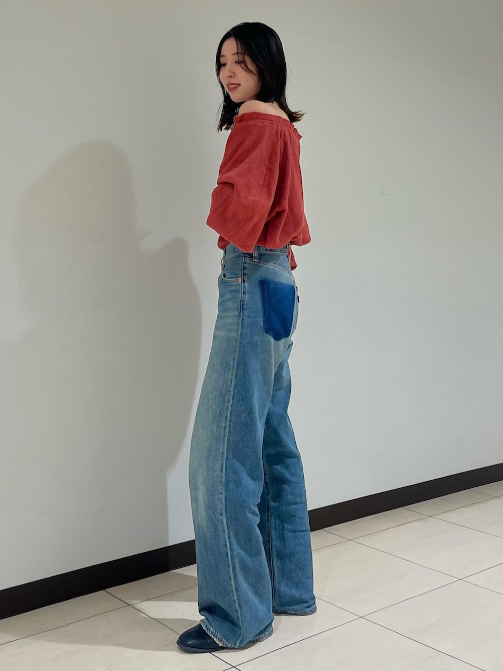 オレンジ系のシャツ/ブラウス、ブルー系のデニムパンツを着用したレディースの夏コーディネートの3枚目の写真