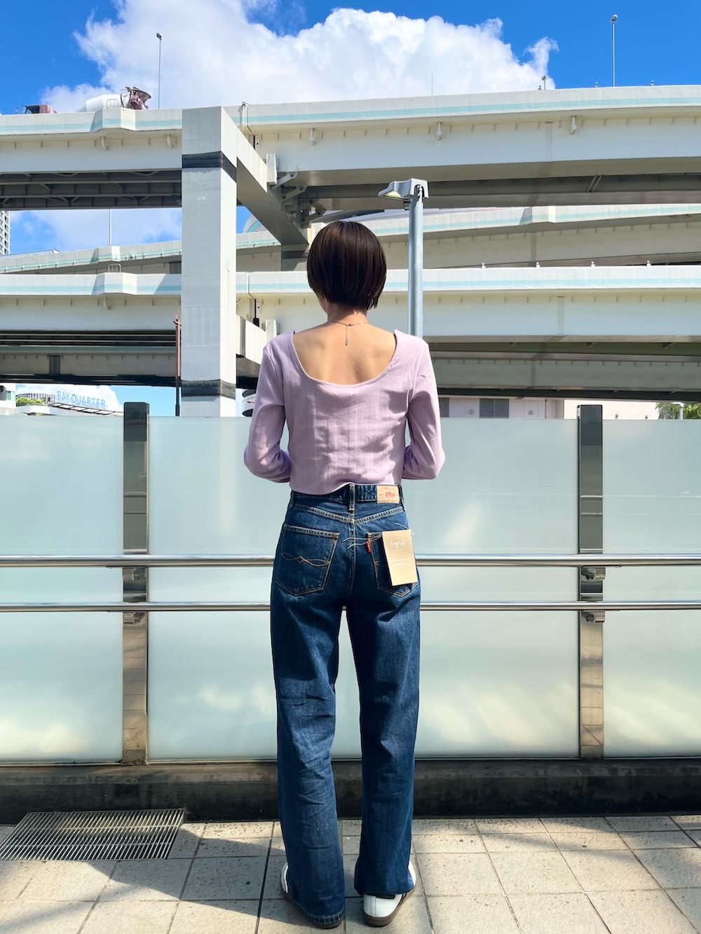 パープル系のTシャツ/カットソー、ブルー系のデニムパンツを着用したレディースの夏コーディネートの3枚目の写真