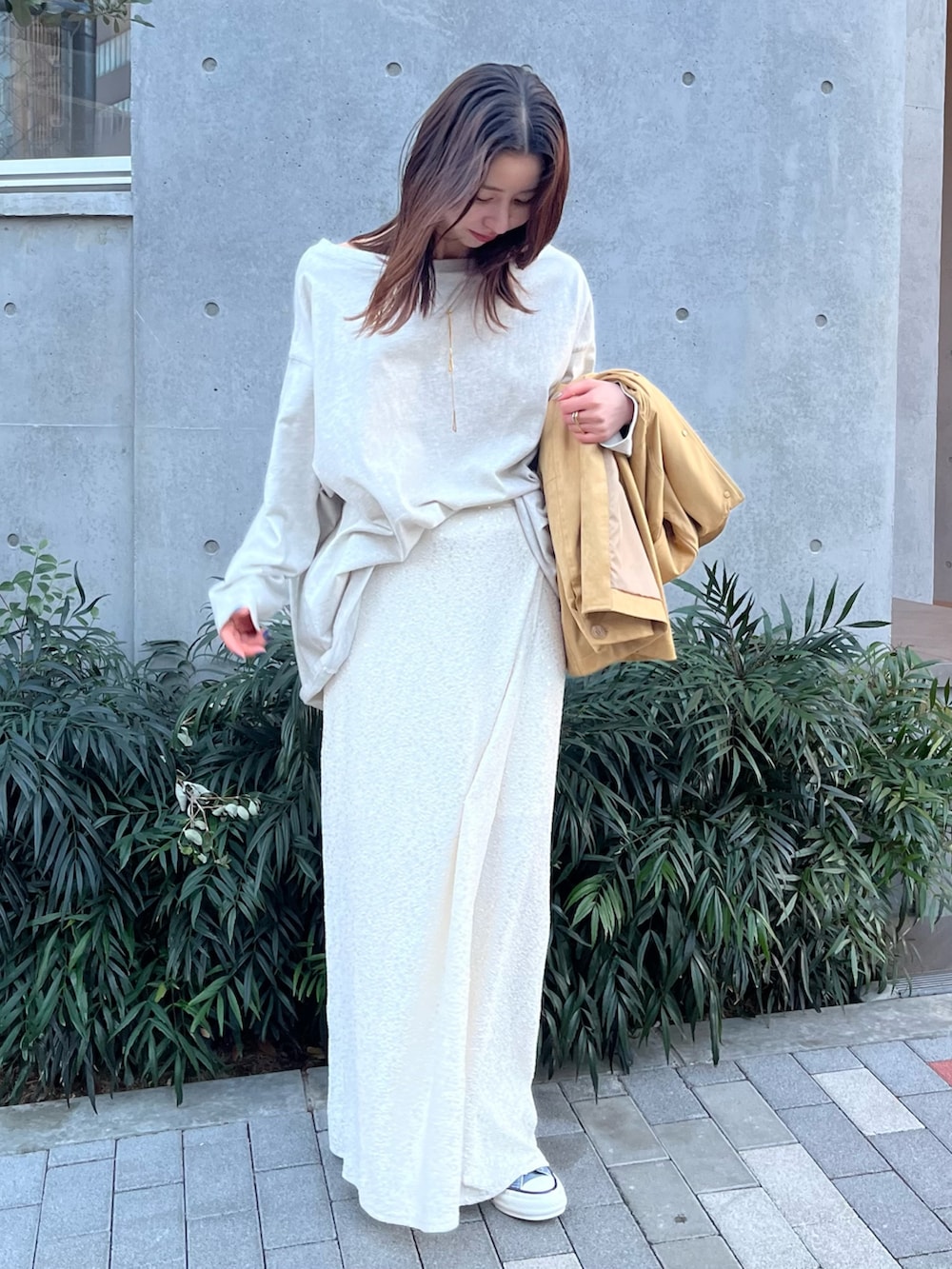 イエロー系のテーラードジャケット、グレー系のTシャツ/カットソー、ホワイト系のスカートを着用したレディースの冬コーディネートの6枚目の写真