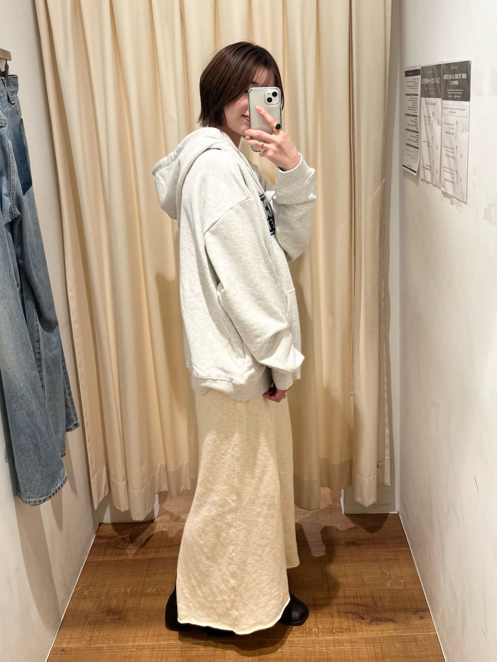 グレー系のパーカー、ホワイト系のスカートを着用したレディースの冬コーディネートの2枚目の写真