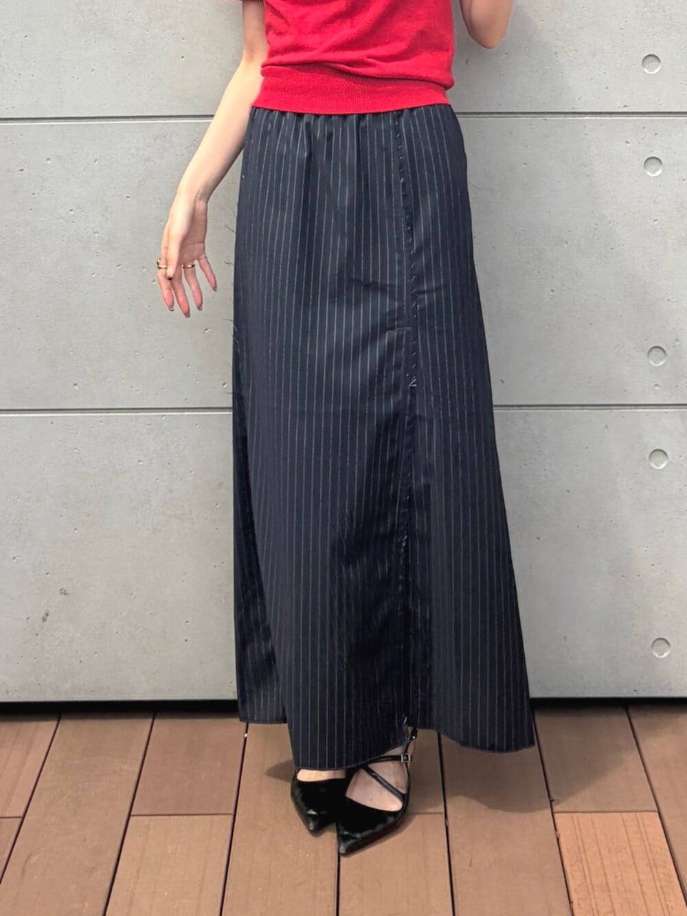 レッド系のニット/セーター、ブルー系のスカート、シルバー系のメガネを着用したレディースの夏コーディネートの5枚目の写真