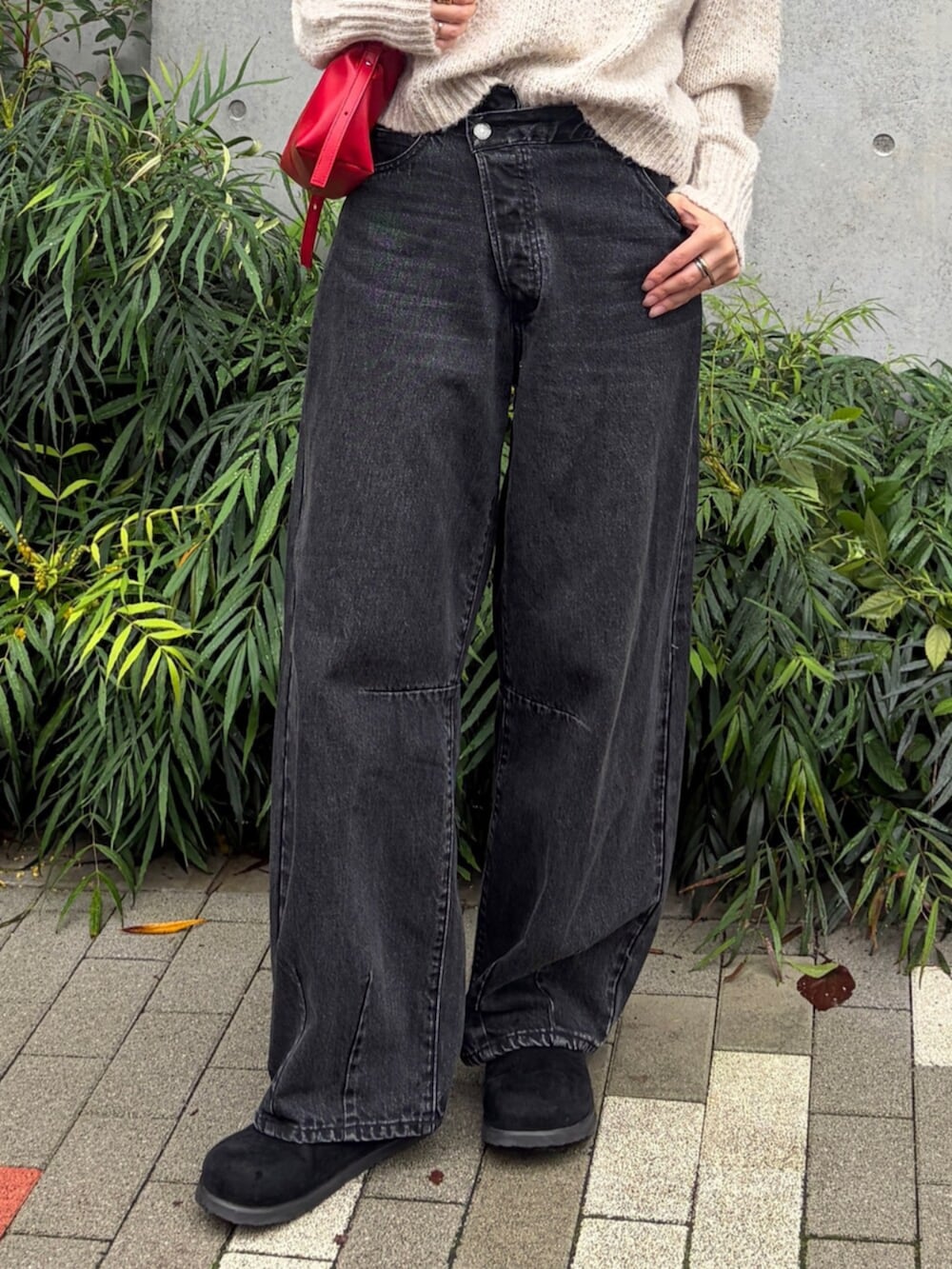 ホワイト系のニット/セーター、ブラック系のデニムパンツ、レッド系のハンドバッグを着用したレディースの秋コーディネートの5枚目の写真