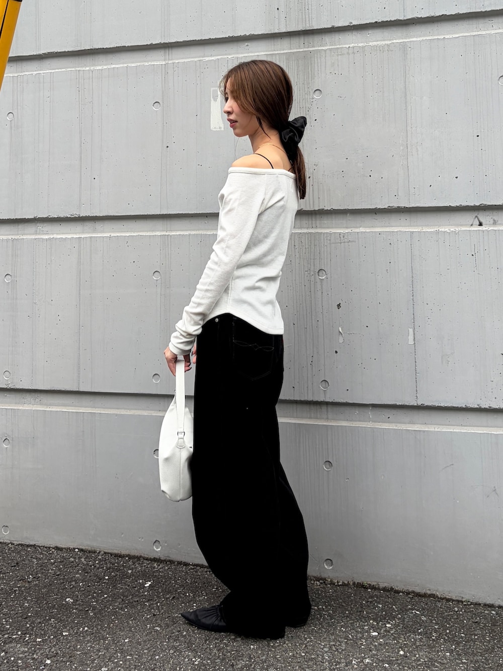 ホワイト系のTシャツ/カットソー、ブラック系のデニムパンツ、ホワイト系のハンドバッグを着用したレディースの秋コーディネートの2枚目の写真