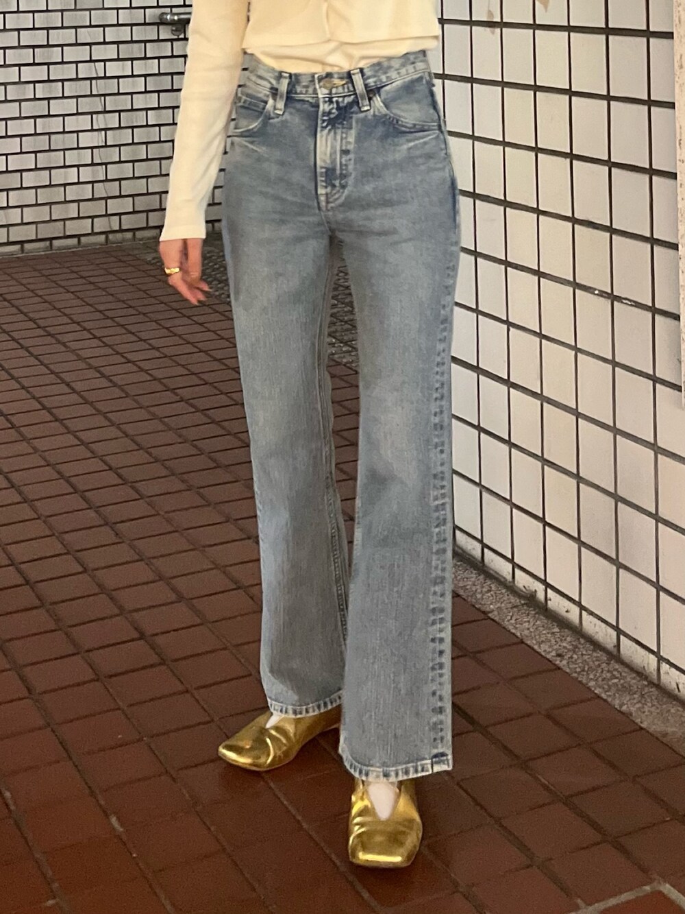 ホワイト系のTシャツ/カットソー、ブルー系のデニムパンツを着用したレディースの春コーディネートの4枚目の写真