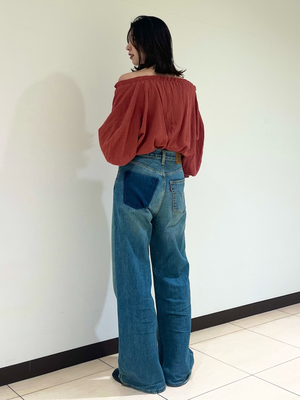 オレンジ系のシャツ/ブラウス、ブルー系のデニムパンツを着用したレディースの夏コーディネートの4枚目の写真