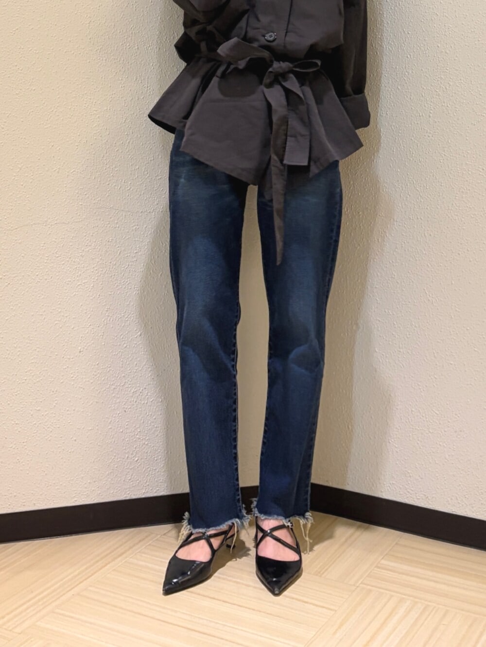 グレー系のトレンチコート、ブルー系のデニムパンツ、ブラック系のサングラスを着用したレディースの夏コーディネートの5枚目の写真