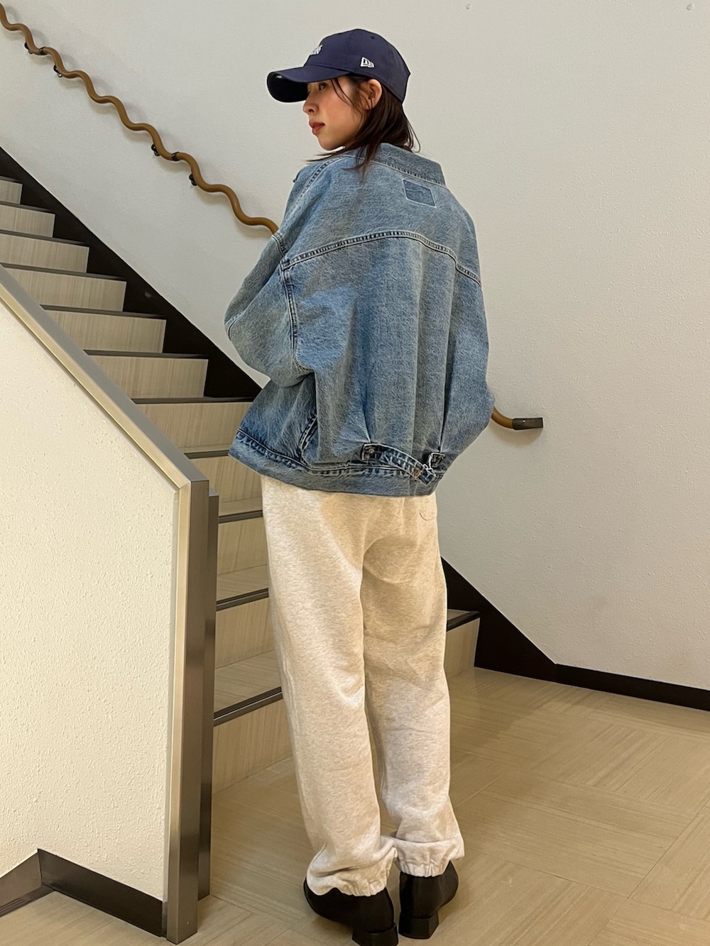 グレー系のTシャツ/カットソー、ブルー系のデニムジャケット、ホワイト系のスウェットパンツを着用したレディースの春コーディネートの3枚目の写真