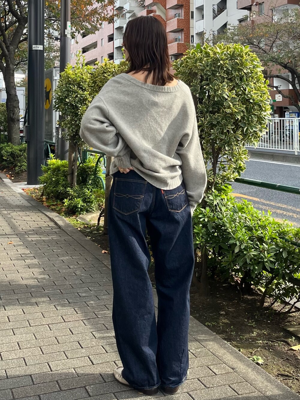 グレー系のニット/セーター、ブルー系のデニムパンツを着用したレディースの秋コーディネートの3枚目の写真