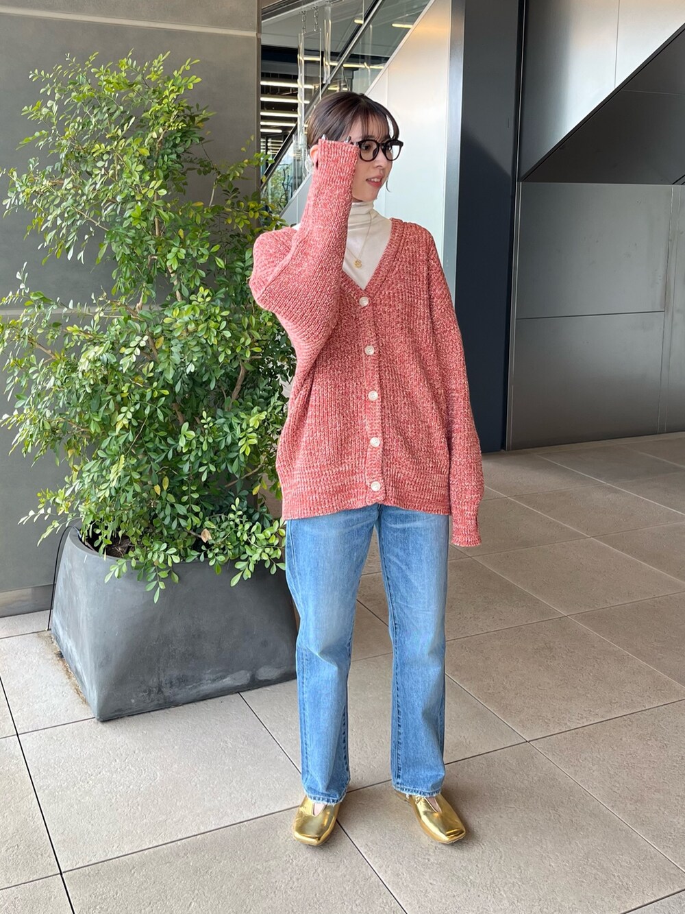 ホワイト系のTシャツ/カットソー、オレンジ系のカーディガン/ボレロ、ブルー系のデニムパンツを着用したレディースの冬コーディネートの2枚目の写真