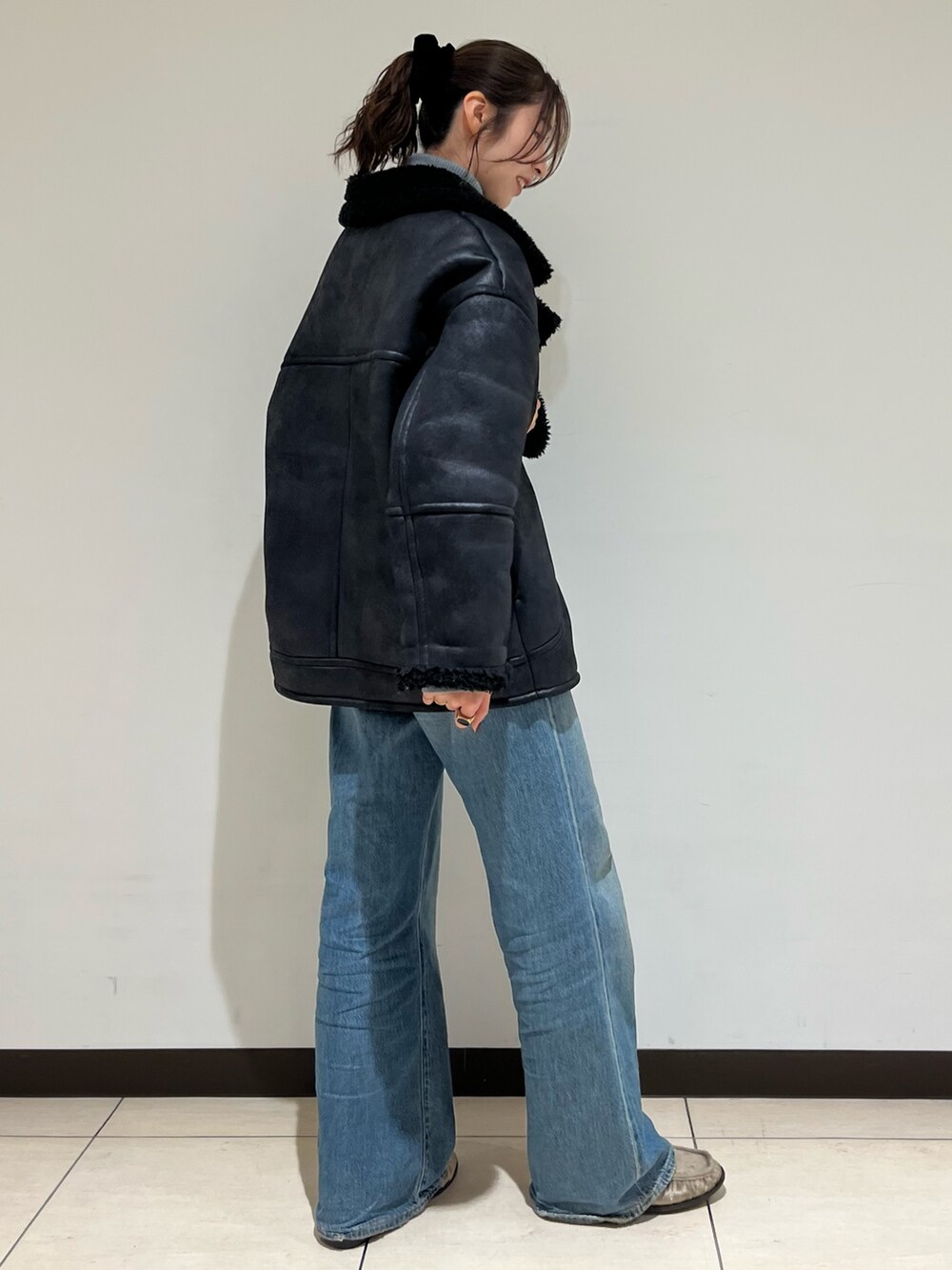 ブラック系のブルゾン、ブルー系のデニムパンツ、ベージュ系のローファーを着用したレディースの冬コーディネートの2枚目の写真