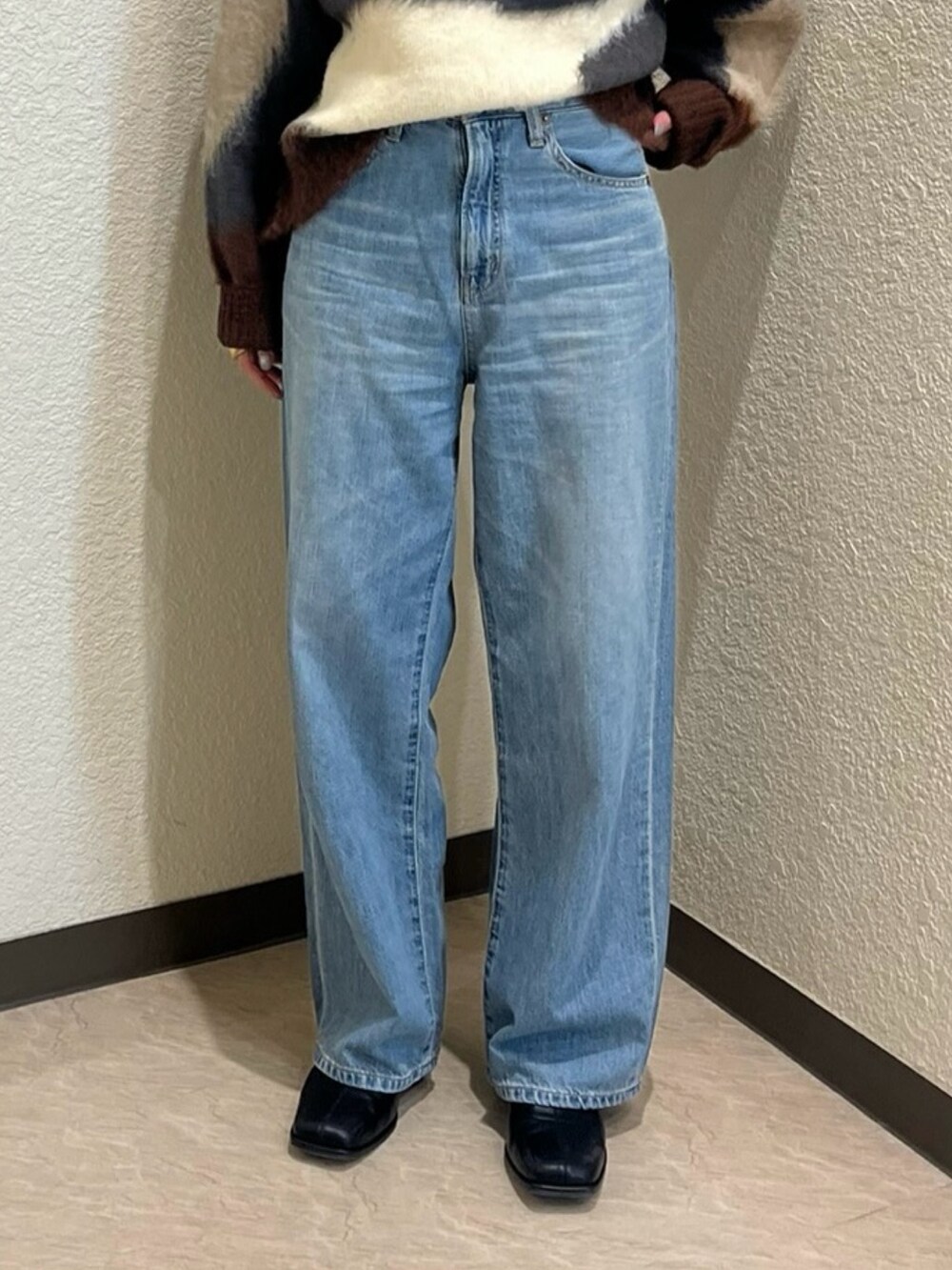 グレー系のニット/セーター、ブルー系のデニムパンツを着用したレディースの秋コーディネートの5枚目の写真