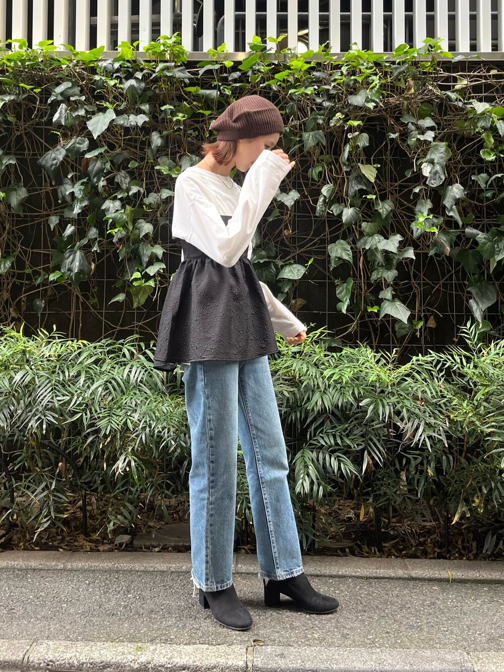ブラック系のキャミソール、ホワイト系のTシャツ/カットソー、ブルー系のデニムパンツを着用したレディースの秋コーディネートの2枚目の写真