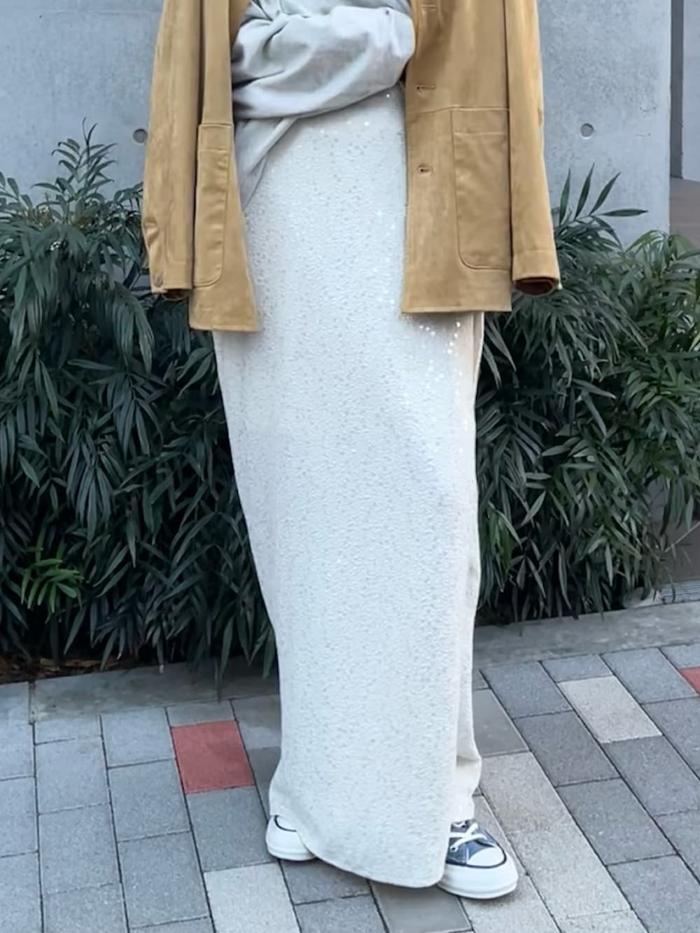 イエロー系のテーラードジャケット、グレー系のTシャツ/カットソー、ホワイト系のスカートを着用したレディースの冬コーディネートの5枚目の写真