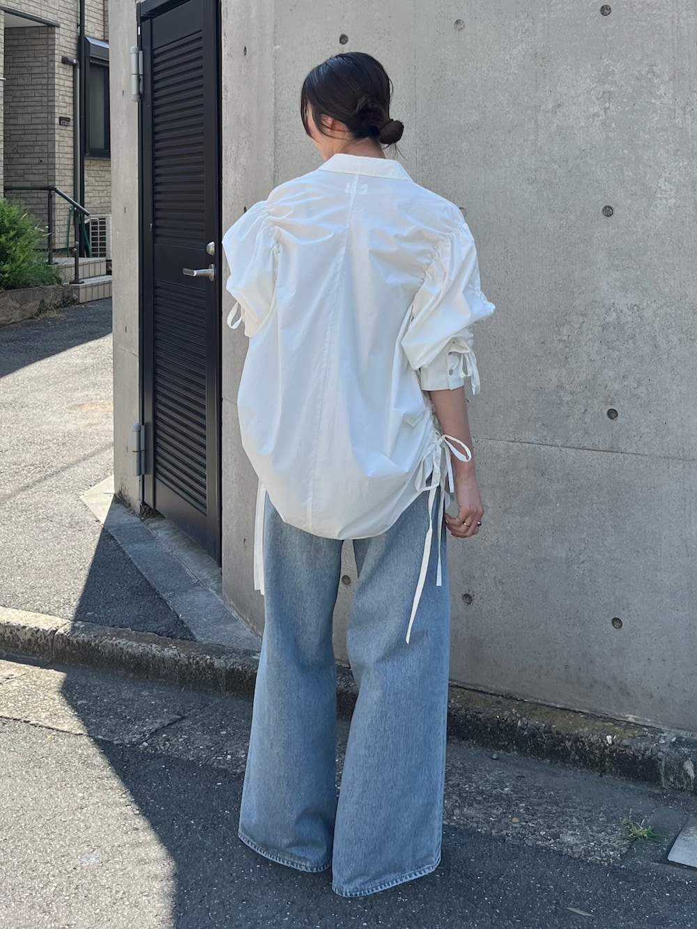 ホワイト系のシャツ/ブラウス、ブルー系のデニムパンツ、ベージュ系のローファーを着用したレディースの秋コーディネートの3枚目の写真