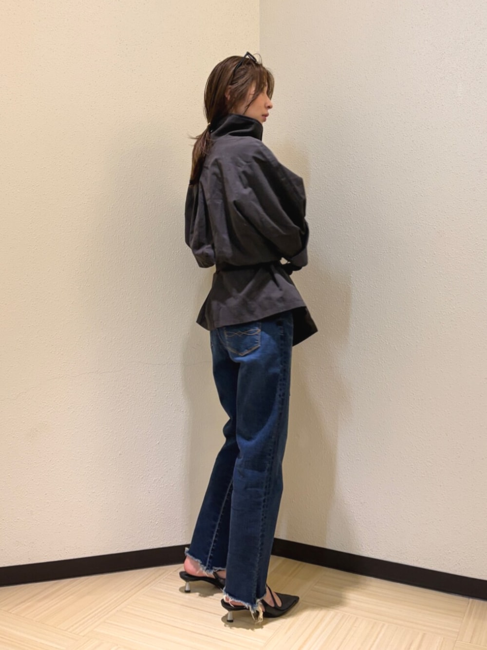 グレー系のトレンチコート、ブルー系のデニムパンツ、ブラック系のサングラスを着用したレディースの夏コーディネートの2枚目の写真