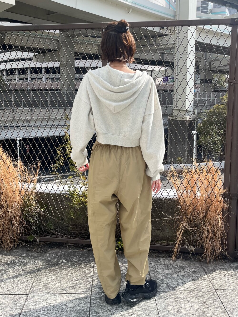 ホワイト系のパーカー、ベージュ系のその他パンツ、ブラック系のスニーカーを着用したレディースの春コーディネートの3枚目の写真