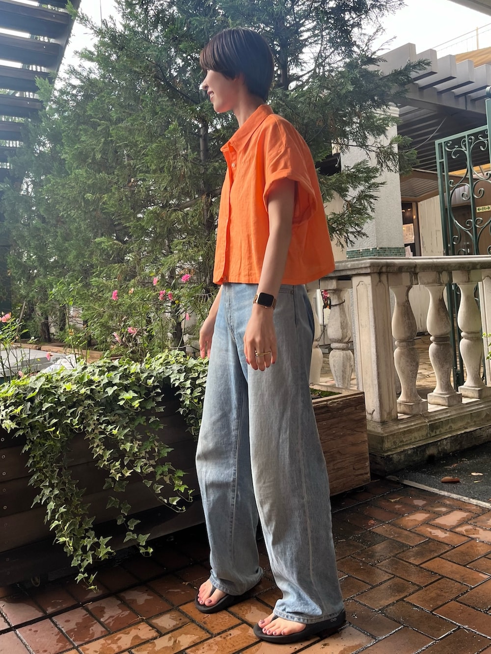 オレンジ系のシャツ/ブラウス、ブルー系のデニムパンツを着用したレディースの夏コーディネートの2枚目の写真