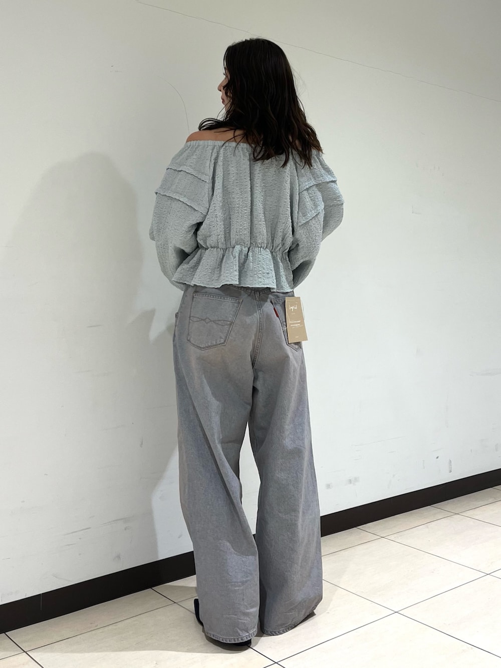 ブルー系のデニムパンツ、ブラック系のパンプスを着用したレディースの春コーディネートの3枚目の写真