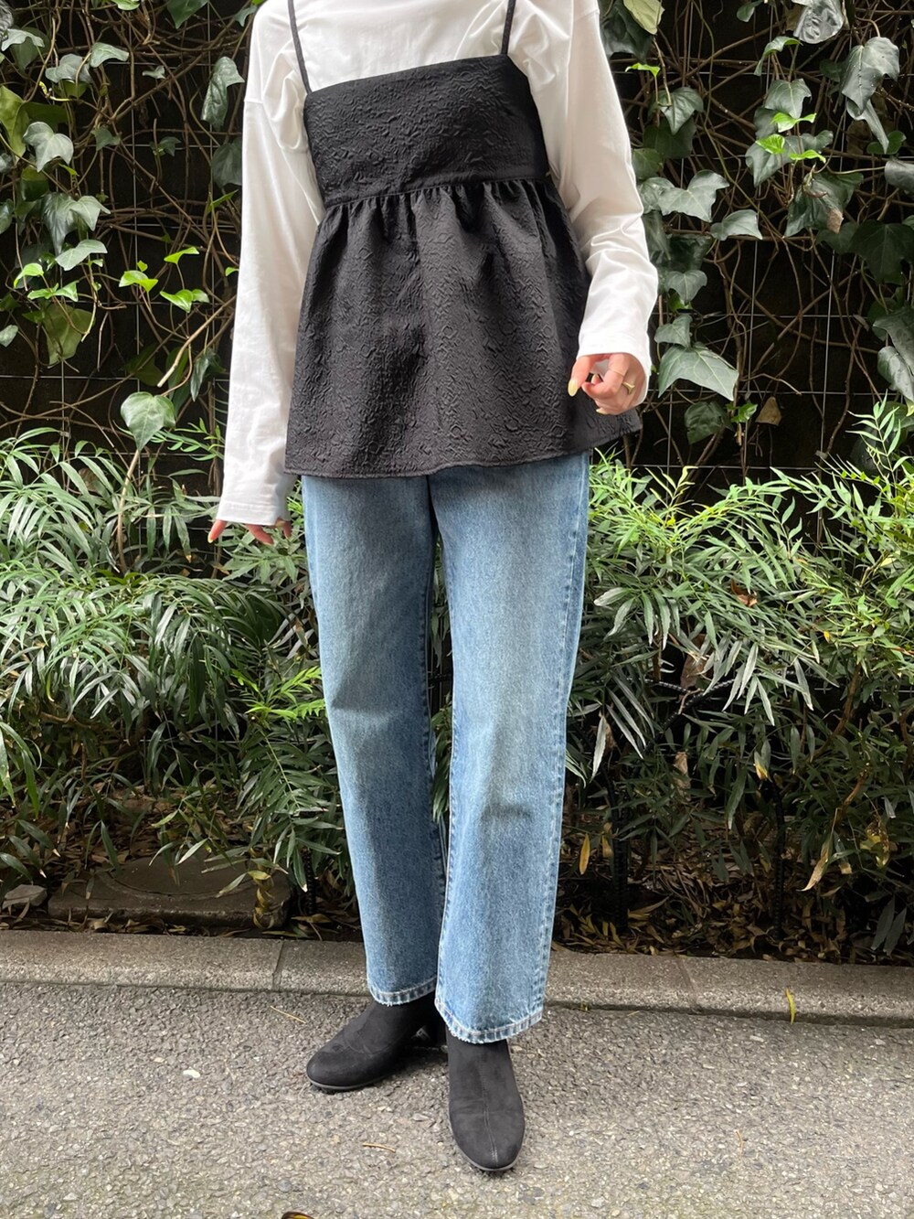 ブラック系のキャミソール、ホワイト系のTシャツ/カットソー、ブルー系のデニムパンツを着用したレディースの秋コーディネートの3枚目の写真