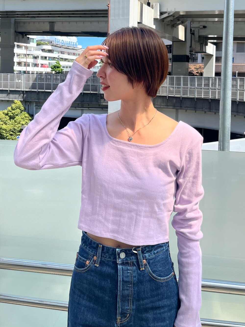 パープル系のTシャツ/カットソー、ブルー系のデニムパンツを着用したレディースの夏コーディネートの4枚目の写真