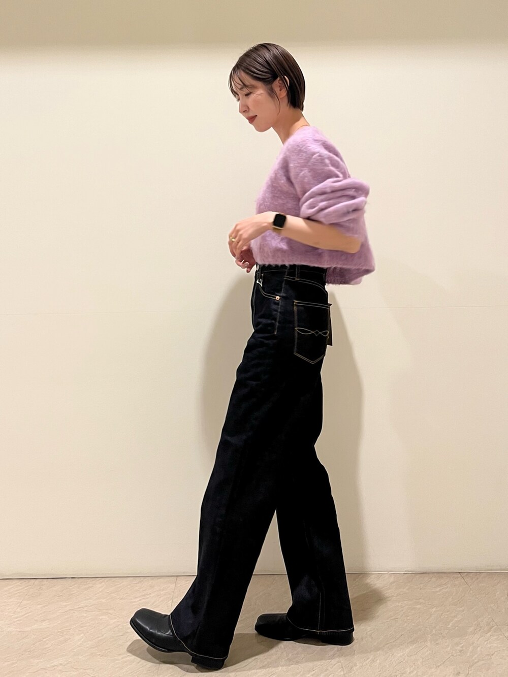 パープル系のニット/セーター、ブルー系のデニムパンツを着用したレディースの秋コーディネートの2枚目の写真