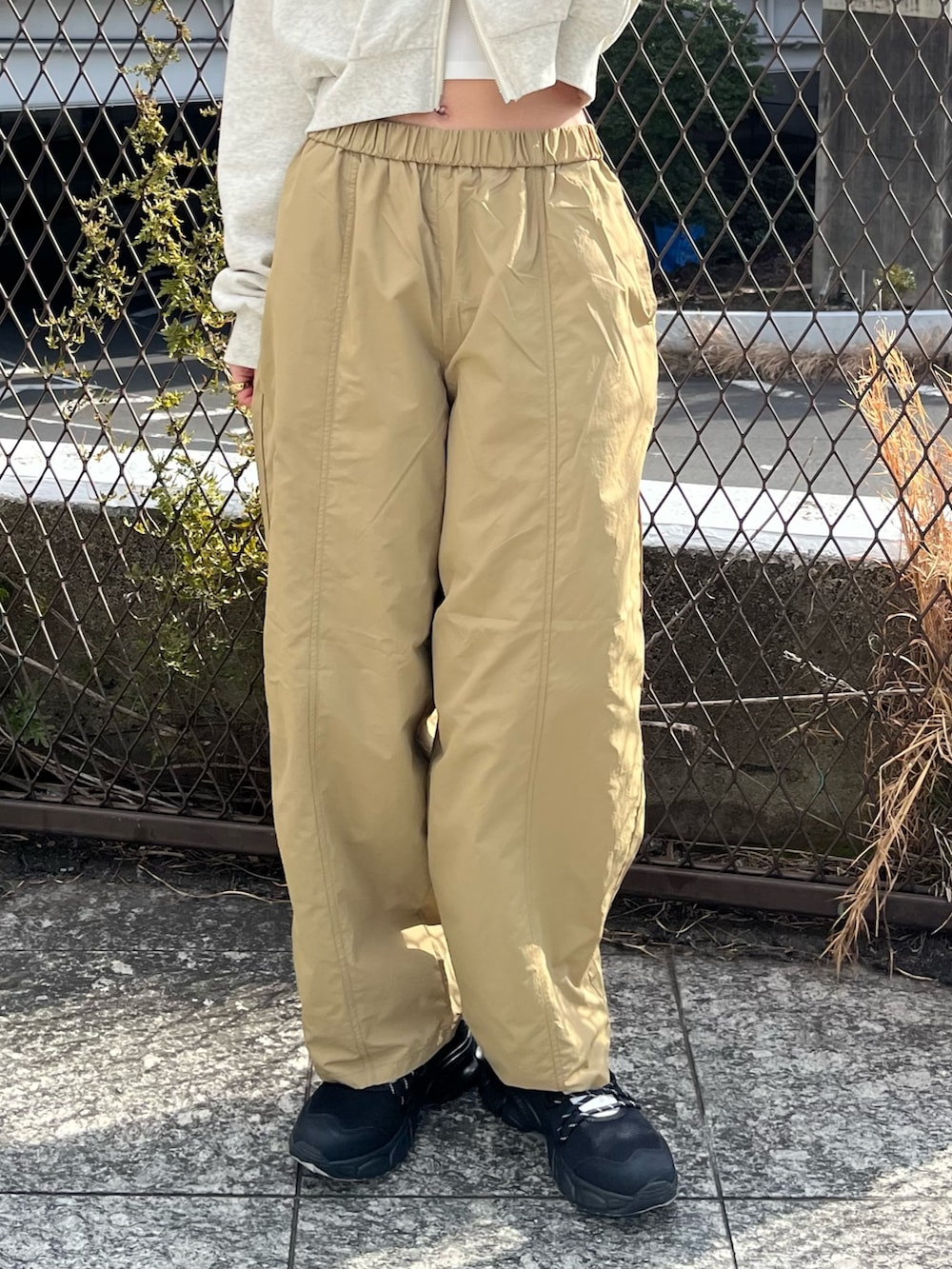 ホワイト系のパーカー、ベージュ系のその他パンツ、ブラック系のスニーカーを着用したレディースの春コーディネートの5枚目の写真