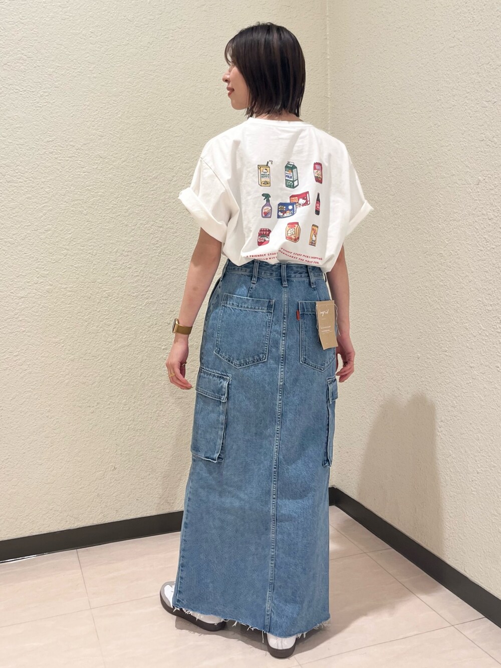 ホワイト系のTシャツ/カットソー、ブルー系のデニムスカートを着用したレディースの春コーディネートの2枚目の写真