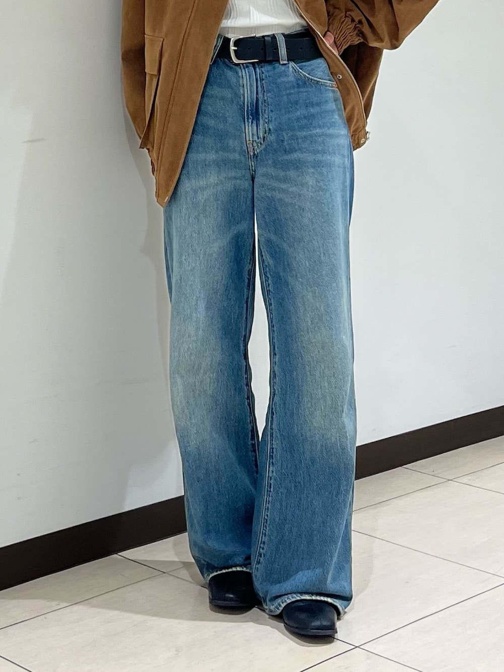 ブルー系のデニムパンツ、ブラウン系のブルゾンを着用したレディースの秋コーディネートの5枚目の写真