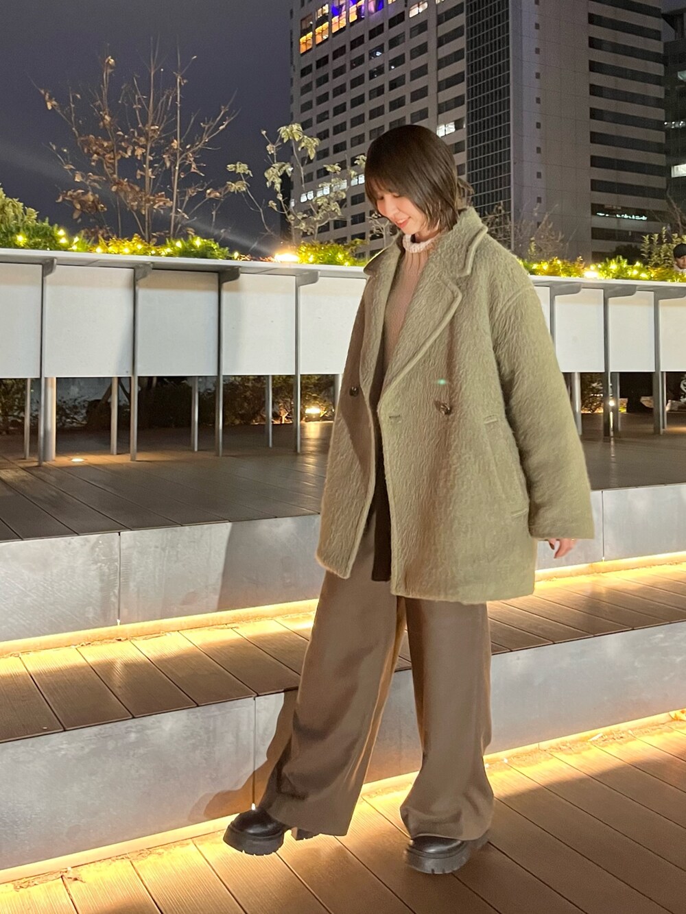 ホワイト系のニット/セーター、グリーン系のピーコート、ブラウン系のその他パンツを着用したレディースの冬コーディネートの4枚目の写真