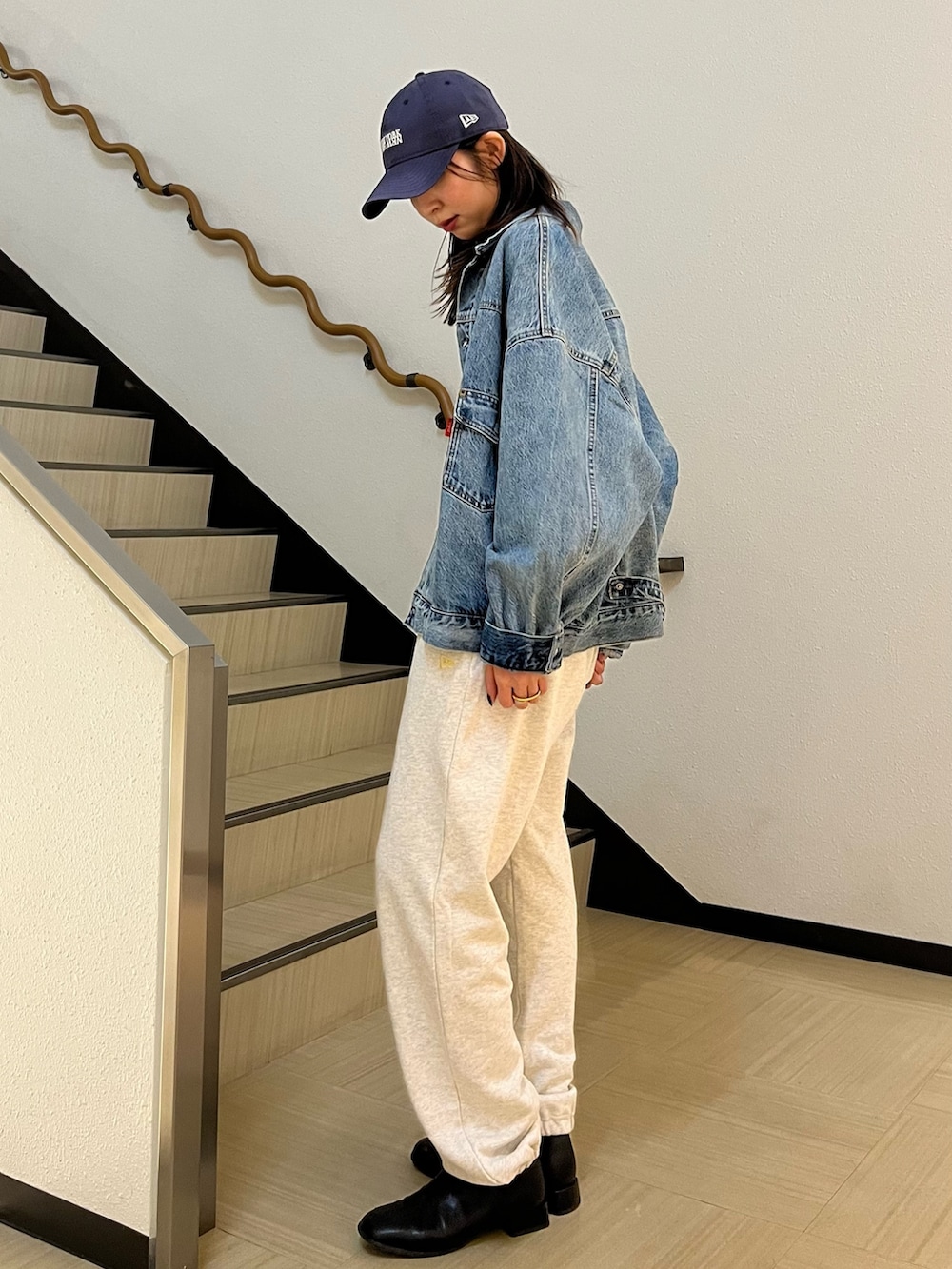 グレー系のTシャツ/カットソー、ブルー系のデニムジャケット、ホワイト系のスウェットパンツを着用したレディースの春コーディネートの2枚目の写真