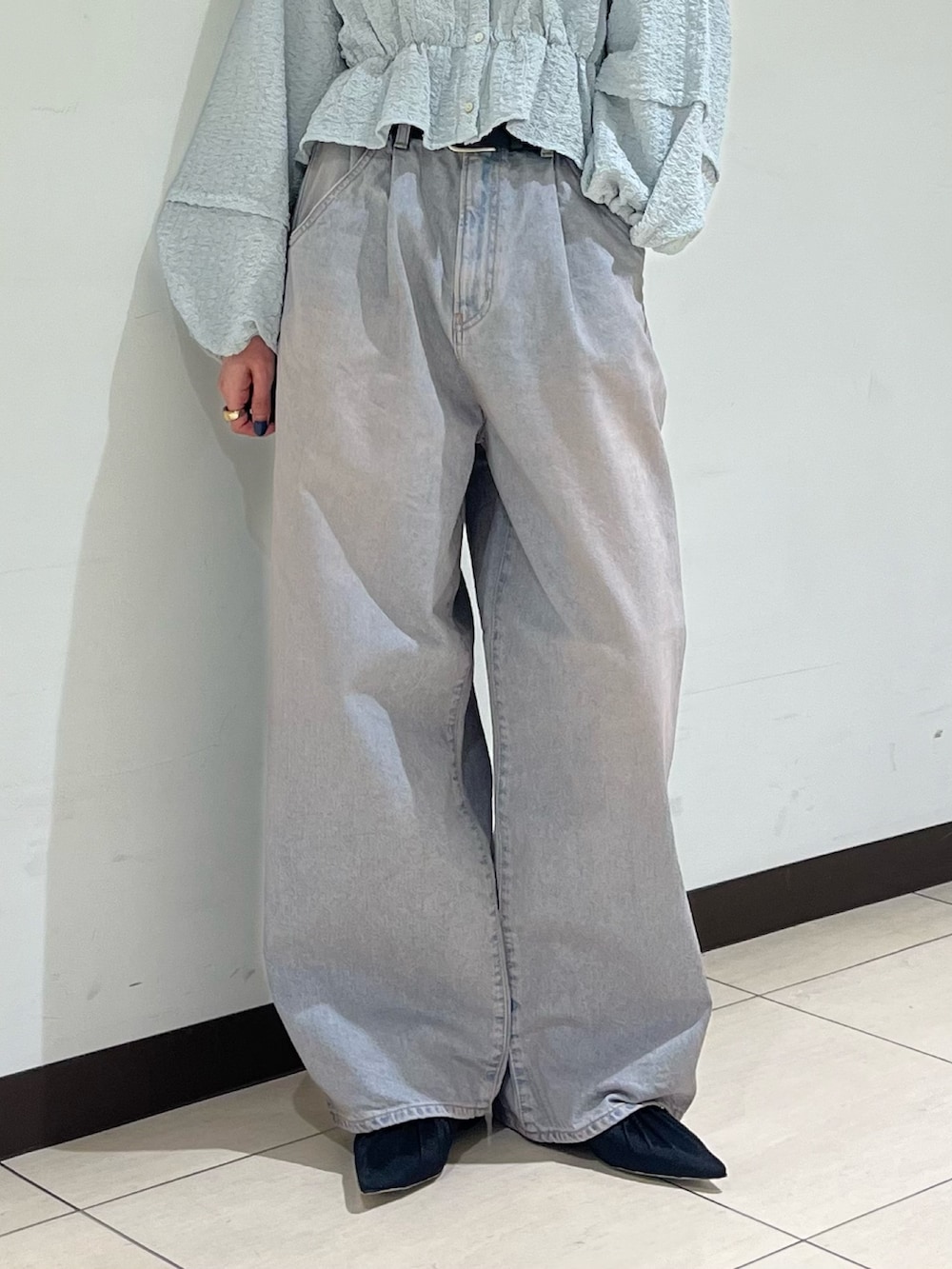 ブルー系のデニムパンツ、ブラック系のパンプスを着用したレディースの春コーディネートの5枚目の写真