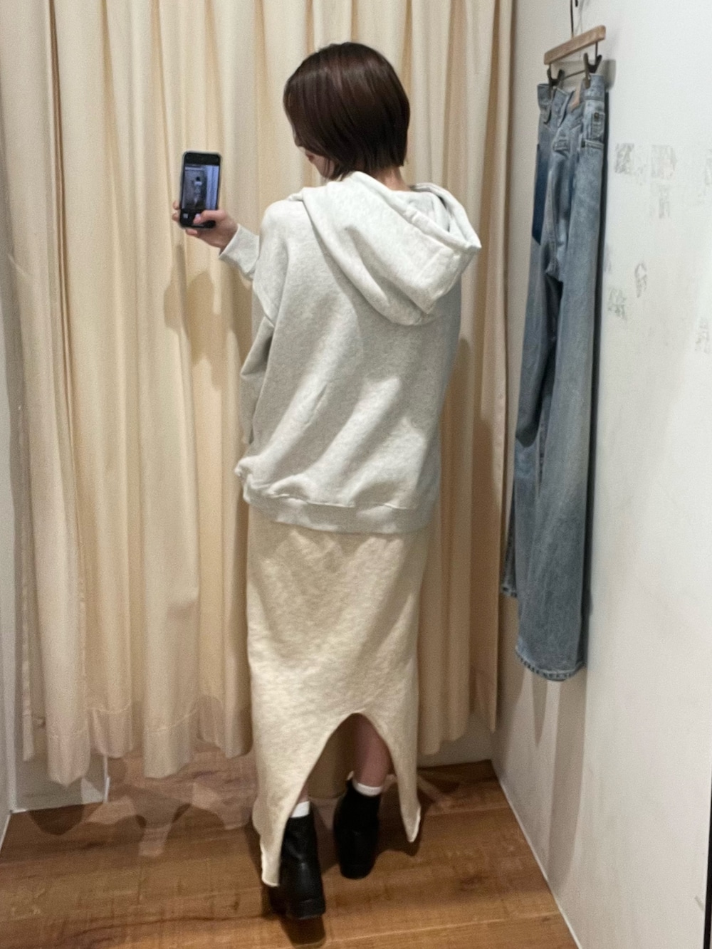 グレー系のパーカー、ホワイト系のスカートを着用したレディースの冬コーディネートの3枚目の写真