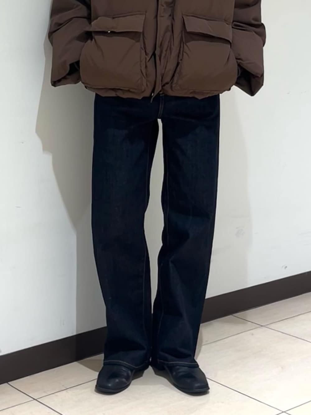ブラウン系のダウンジャケット/コート、ブルー系のデニムパンツ、ブラック系のサングラスを着用したレディースの冬コーディネートの7枚目の写真