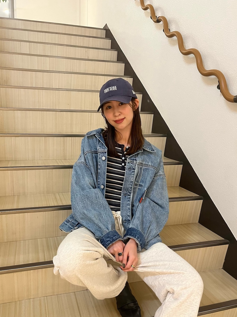 グレー系のTシャツ/カットソー、ブルー系のデニムジャケット、ホワイト系のスウェットパンツを着用したレディースの春コーディネートの4枚目の写真