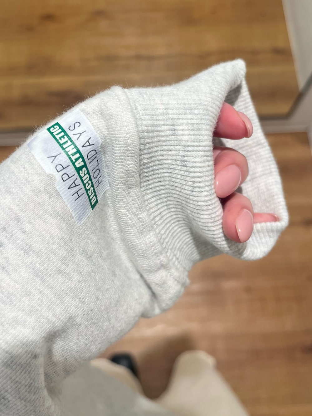 グレー系のパーカー、ホワイト系のスカートを着用したレディースの冬コーディネートの6枚目の写真