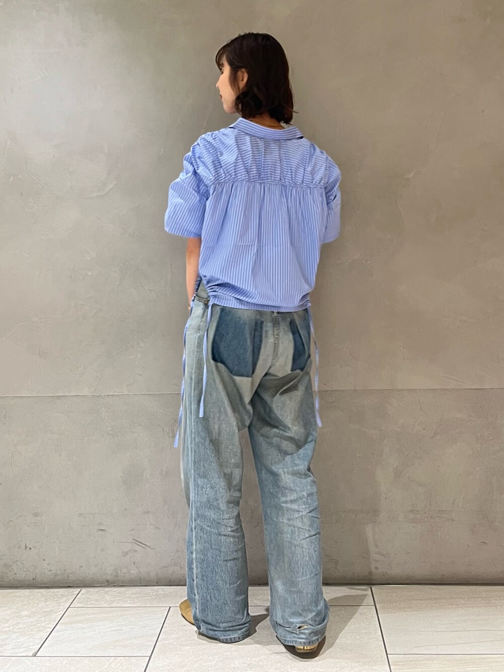 ホワイト系のタンクトップ、ブルー系のシャツ/ブラウス、ブルー系のデニムパンツを着用したレディースの春コーディネートの3枚目の写真