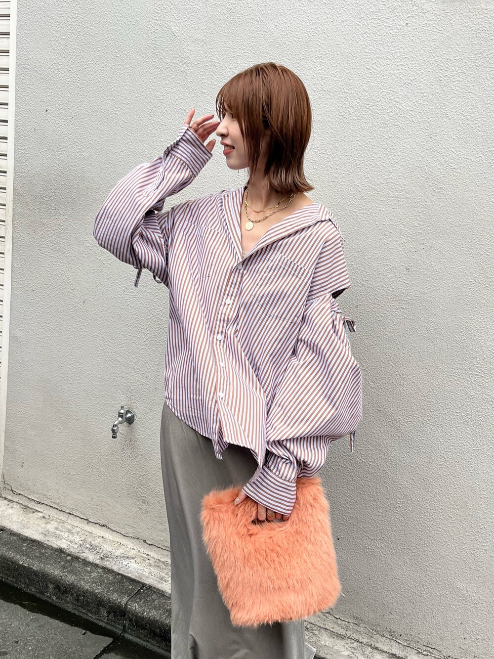 オレンジ系のハンドバッグ、ブラウン系のシャツ/ブラウス、グレー系のスカートを着用したレディースの秋コーディネートの4枚目の写真