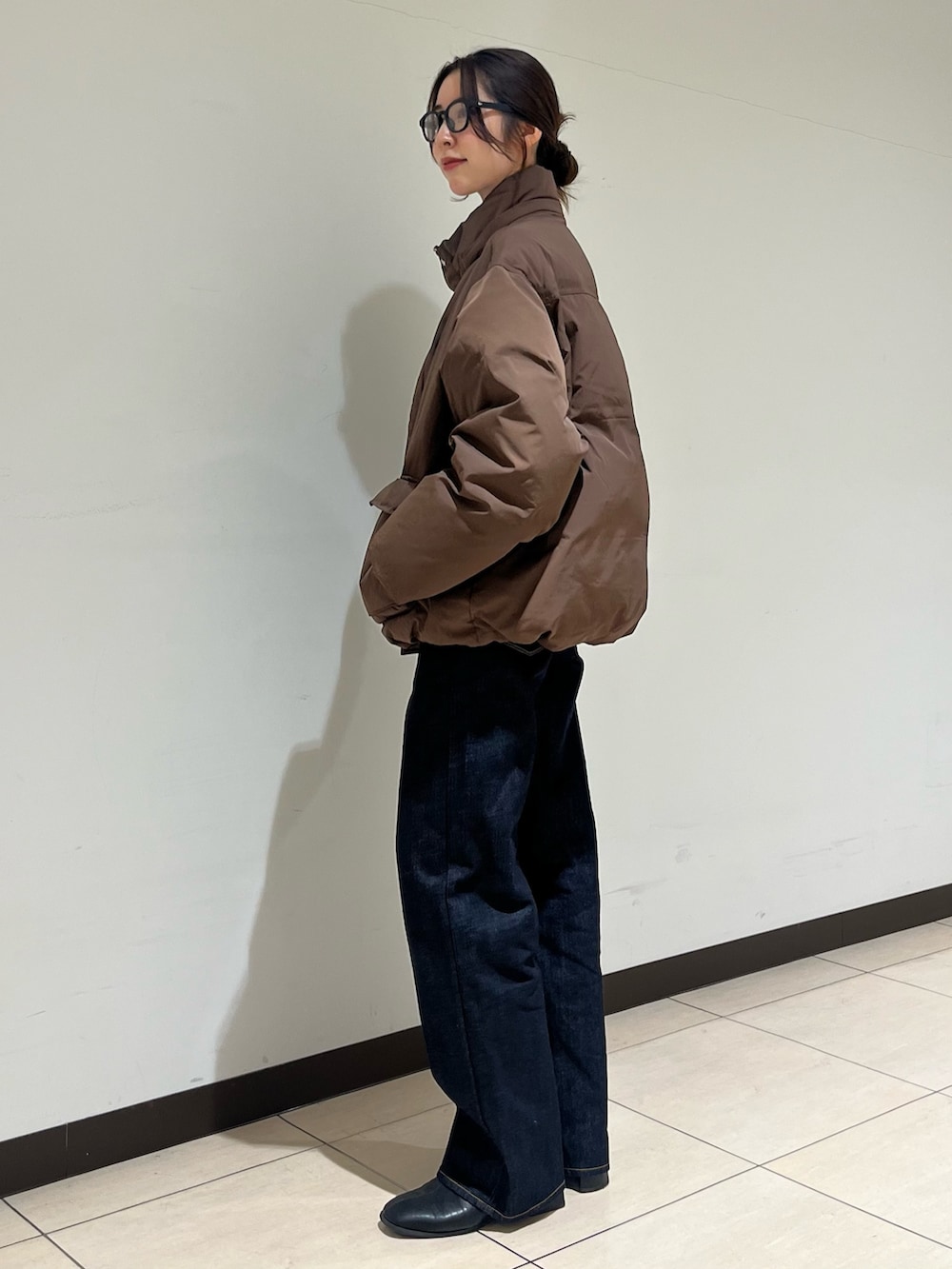 ブラウン系のダウンジャケット/コート、ブルー系のデニムパンツ、ブラック系のサングラスを着用したレディースの冬コーディネートの5枚目の写真