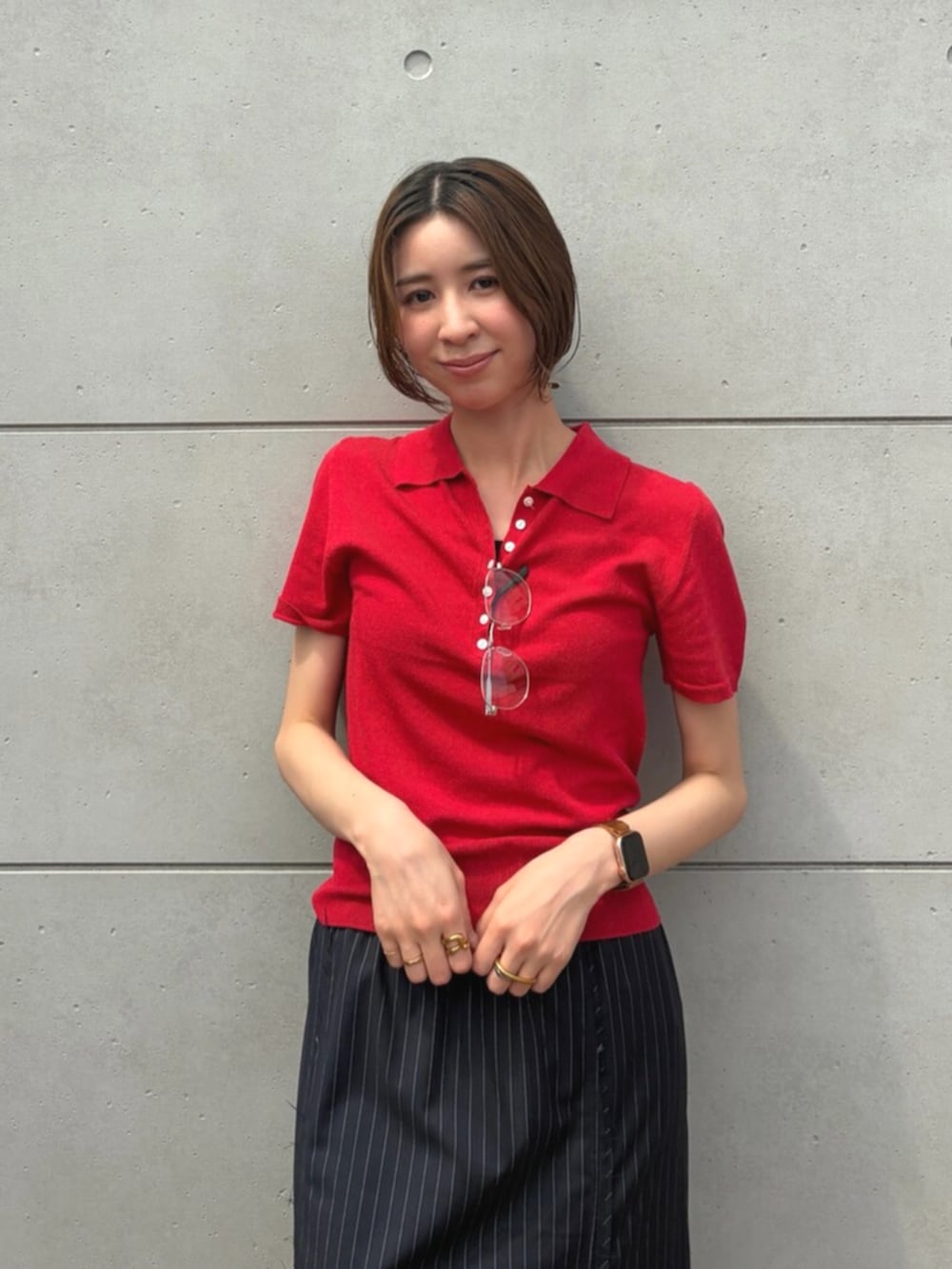 レッド系のニット/セーター、ブルー系のスカート、シルバー系のメガネを着用したレディースの夏コーディネートの4枚目の写真