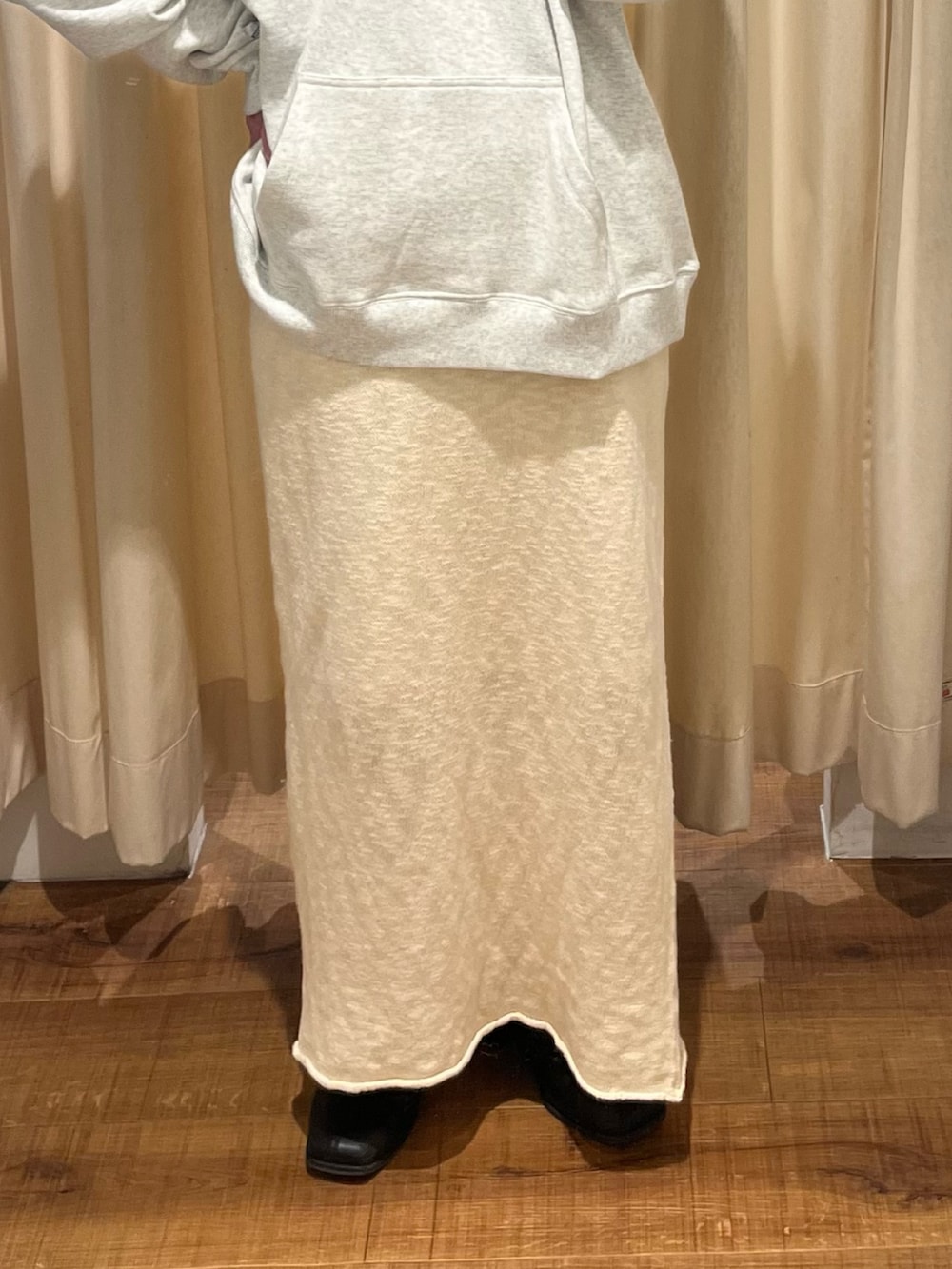 グレー系のパーカー、ホワイト系のスカートを着用したレディースの冬コーディネートの5枚目の写真